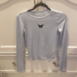 Blue long sleeve shirt with a butterfly logo/patch